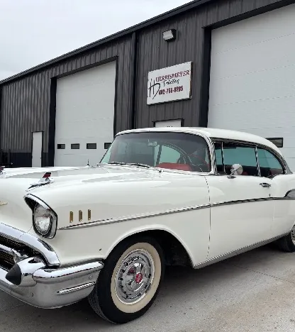 Classic white and red 1957 Chevrolet Bel Air after detailing, parked outside the shop