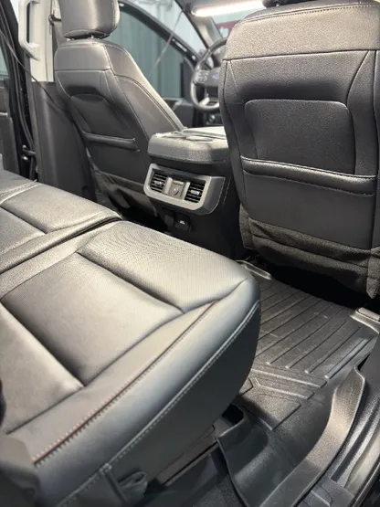 Truck interior with clean black leather bucket seats after detailing