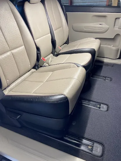 Minivan interior with clean tan and black leather bench seats after detailing