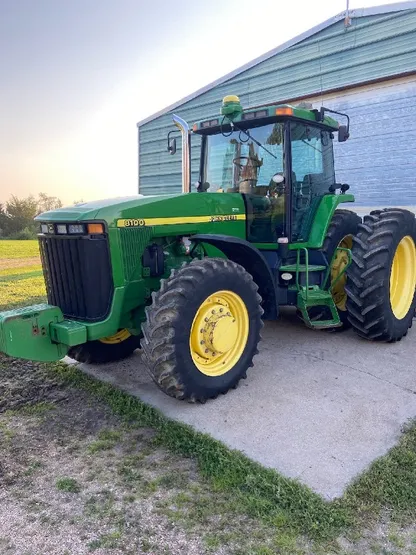 Green tractor exterior after detailing at dusk near a blue shed