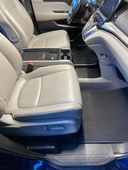 Minivan interior with clean white leather seats after detailing