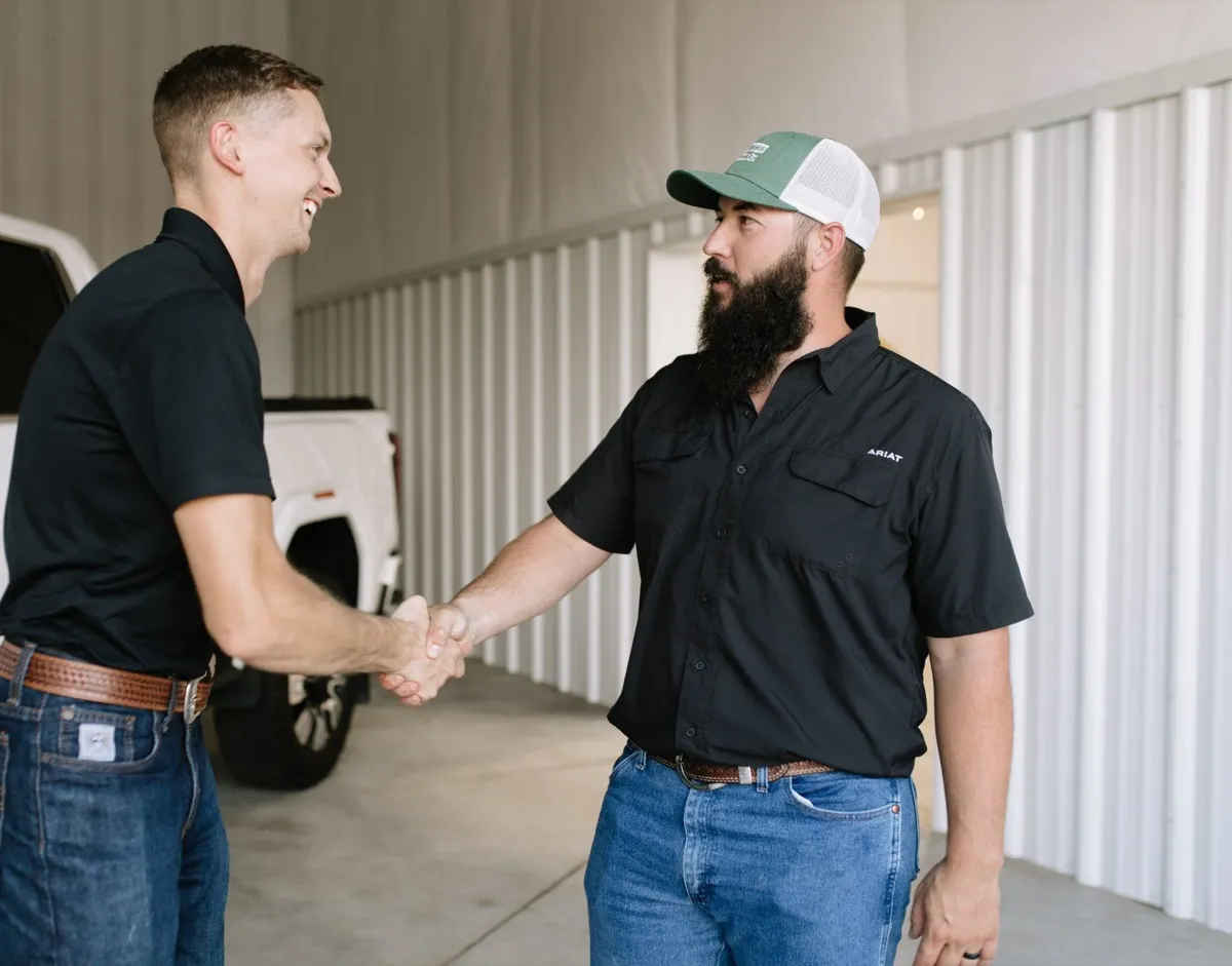 Rusty Hermsmeyer greeting a customer with a handshake at the Hermsmeyer Detailing shop