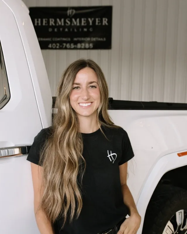 Linzie Hermsmeyer, co-owner of Hermsmeyer Detailing, smiling in front of a white truck