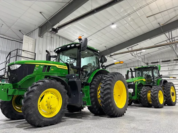 Two green John Deere tractors after detailing, parked in the Hermsmeyer Detailing shop